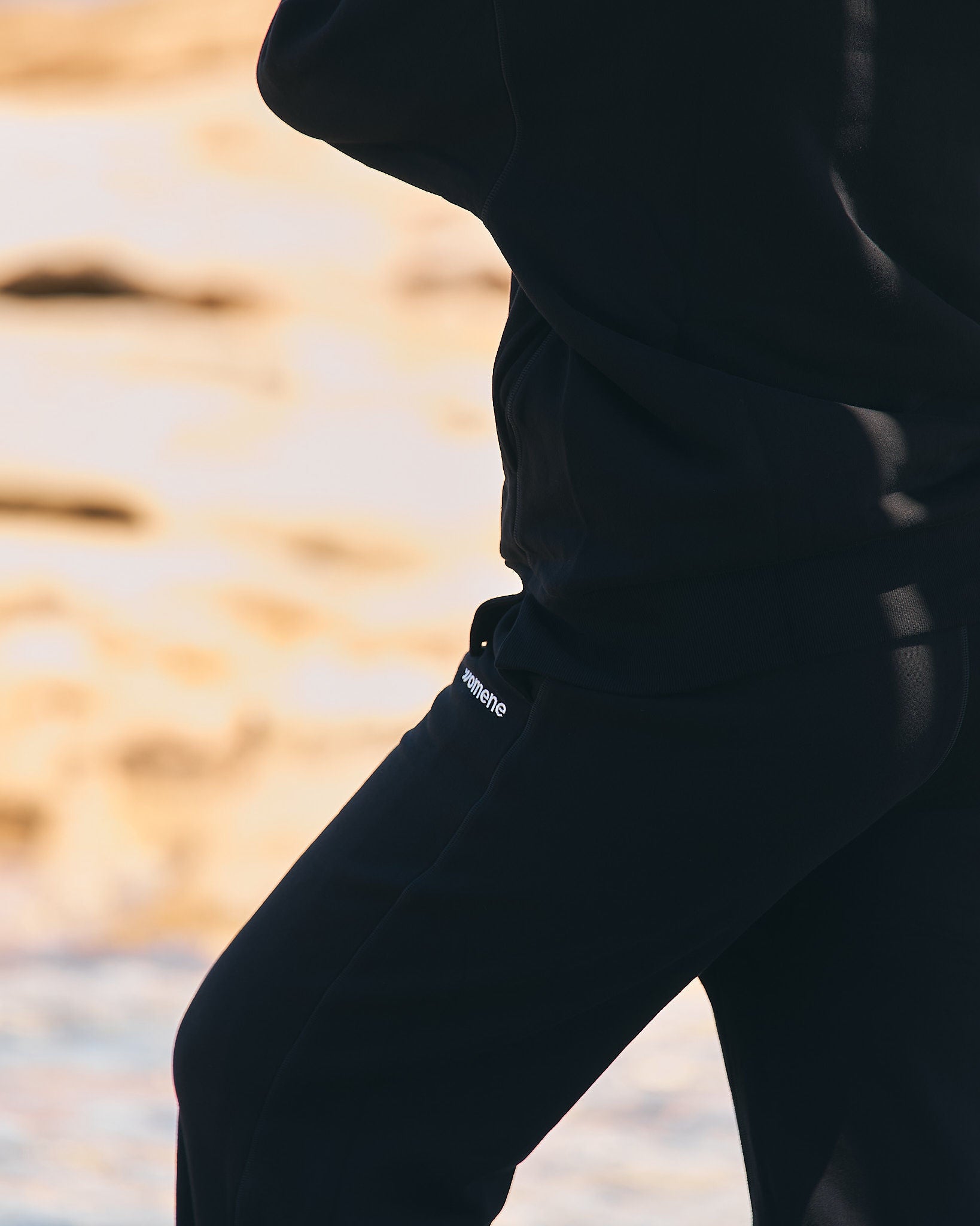 Side profile of Womene Lounge Set in black, showing the classic hoodie fit and straight leg joggers