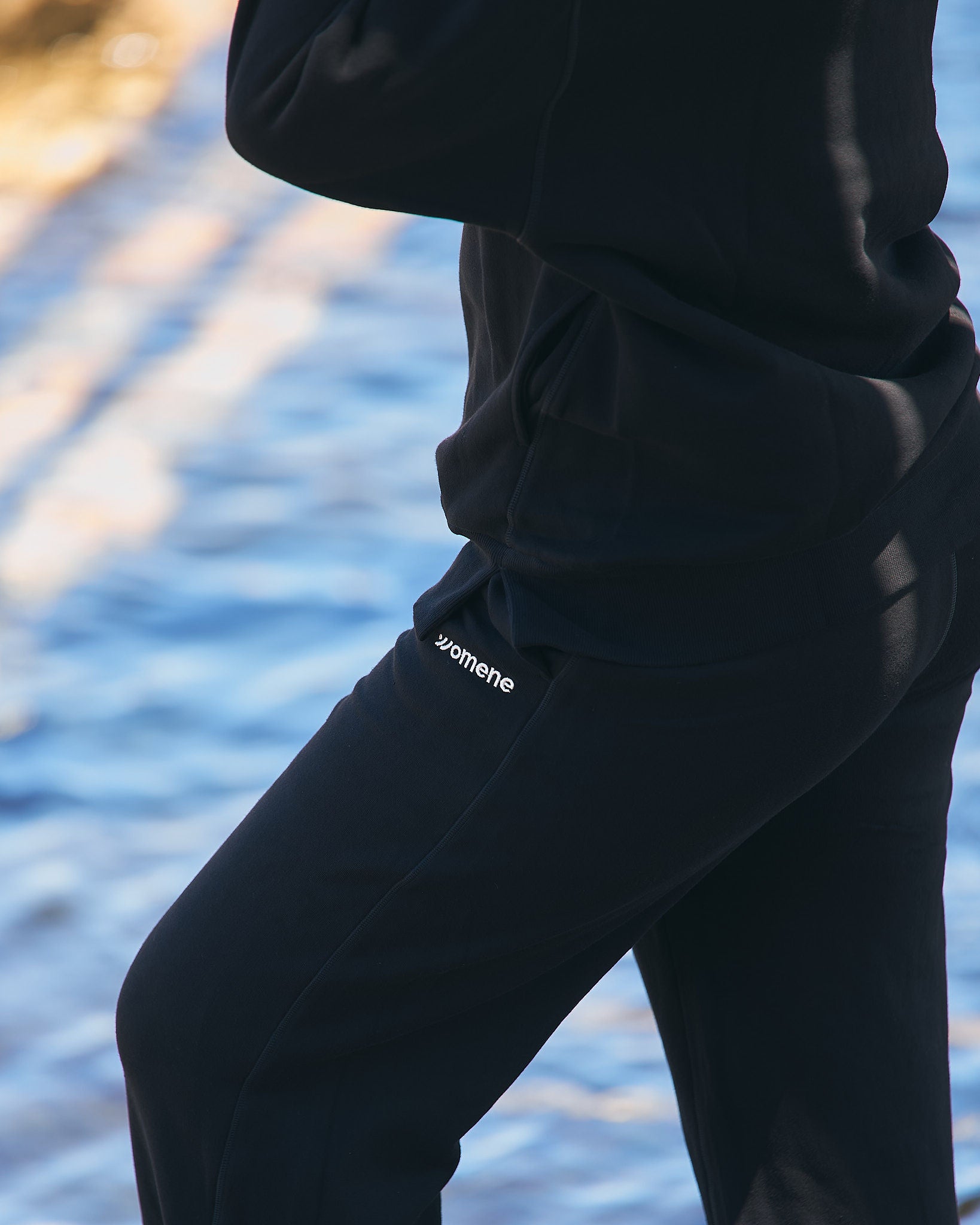 Side profile of Womene Lounge Set in black, showing the classic hoodie fit and straight leg joggers