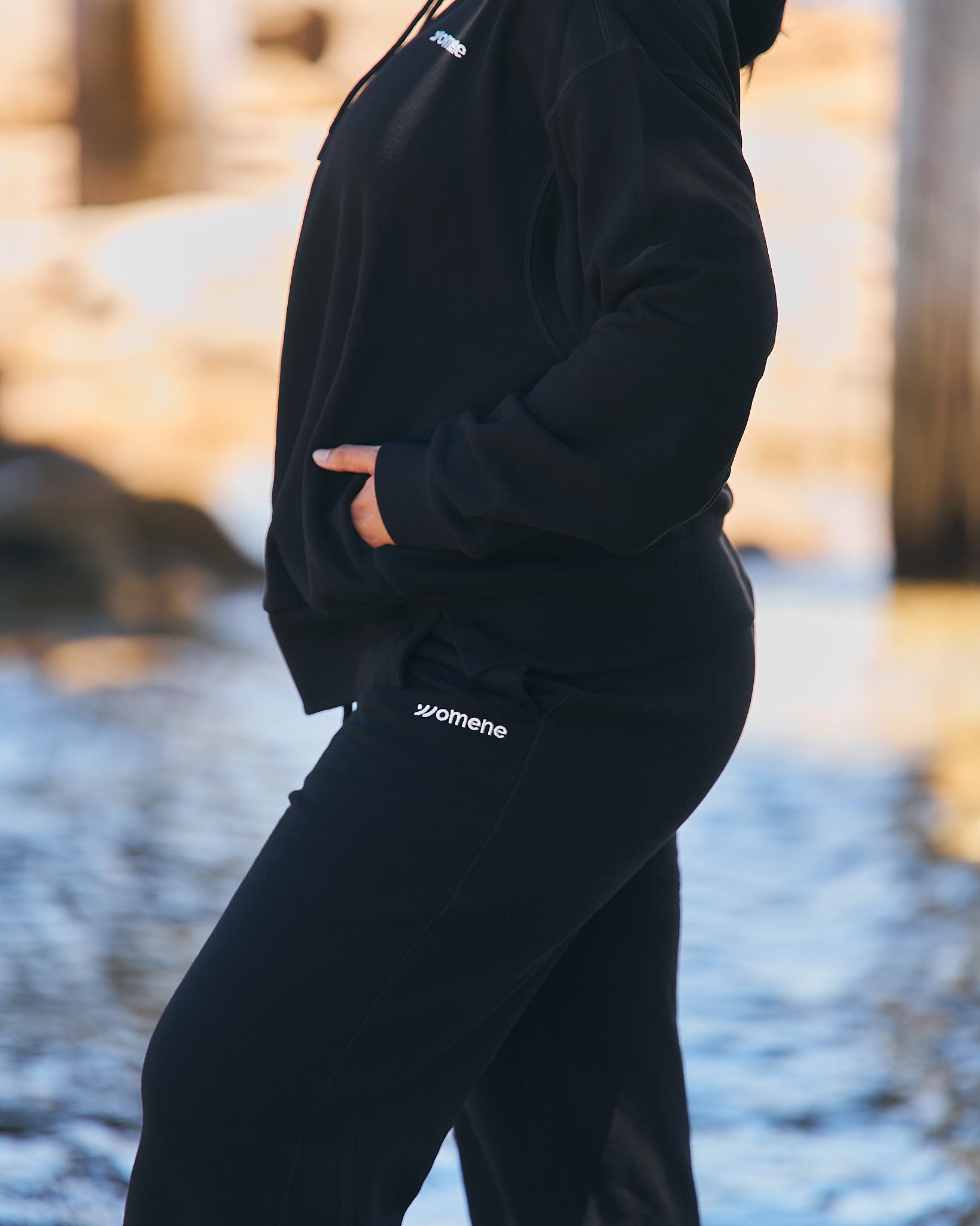 Side profile of Womene Lounge Set in black, showing the classic hoodie fit and straight leg joggers