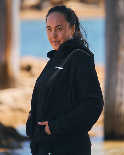 Three-quarter view of Womene Lounge Set in black, hood up, cotton hoodie and matching joggers